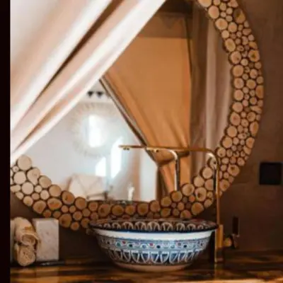 a bowl on a table in front of a mirror at Best Merzouga traductional camp in Merzouga