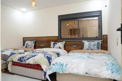 a bedroom with two beds and a mirror at Gite Atlas Tigrigra