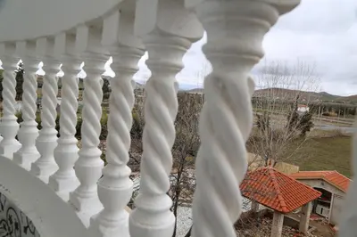 a white railing on a balcony with a view of a yard at Gite Atlas Tigrigra