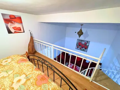 a room with a bed and a staircase with paintings at ZenStay Residences Modern Apartments Near City Center With Balcony And Wifi in Fès