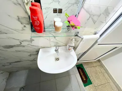 a white sink in a bathroom with a window at ZenStay Residences Modern Apartments Near City Center With Balcony And Wifi in Fès