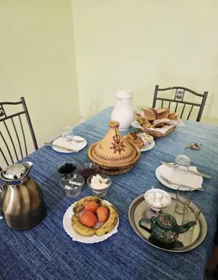 a blue table with plates of food and a tea kettle at Maison zahra merzouga in Merzouga