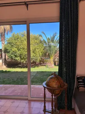 a sliding glass door with a view of a palm tree at Private pool villa & garden Marrakech in Marrakech