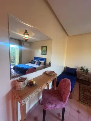 a bedroom with a bed and a table and a mirror at Private pool villa & garden Marrakech in Marrakech