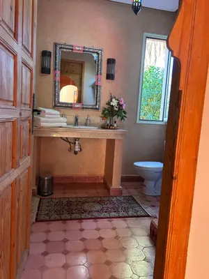 a bathroom with a sink and a mirror and a toilet at Private pool villa & garden Marrakech in Marrakech