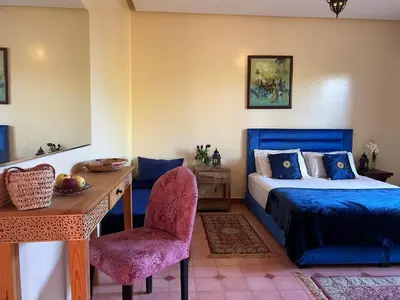 a bedroom with a bed and a desk and a chair at Private pool villa & garden Marrakech in Marrakech
