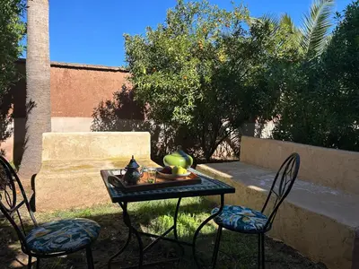 two chairs and a table with a tea set on it at Private pool villa & garden Marrakech in Marrakech