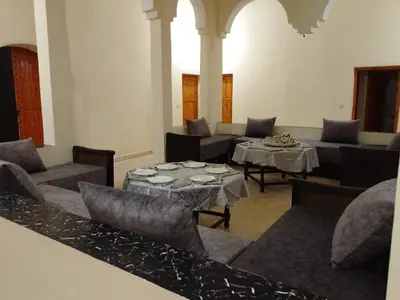 a living room with couches and a table and chairs at Kasbah Anisi