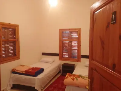 a small room with two beds and a window at Kasbah Anisi