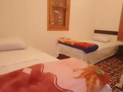 a room with two beds and a window at Kasbah Anisi