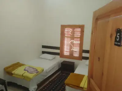 a bedroom with two beds and a window at Kasbah Anisi