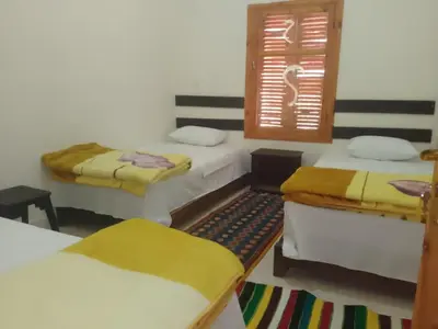 a room with three beds and a window at Kasbah Anisi