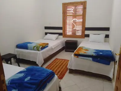 a room with two beds and a window at Kasbah Anisi
