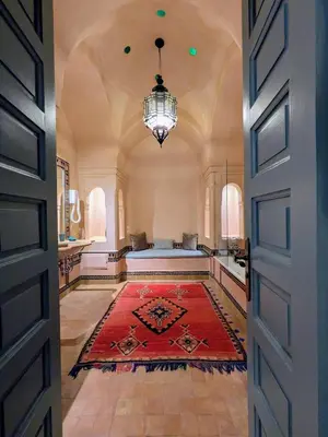 a large room with a red rug and a chandelier at Villa Riad Marrakech in Najem