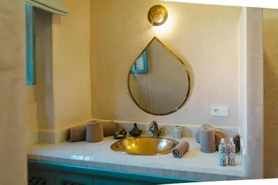 a bathroom with a gold sink and a mirror at Villa Riad Marrakech in Najem