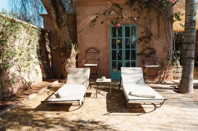 two chairs and a table in front of a house at Villa Riad Marrakech in Najem