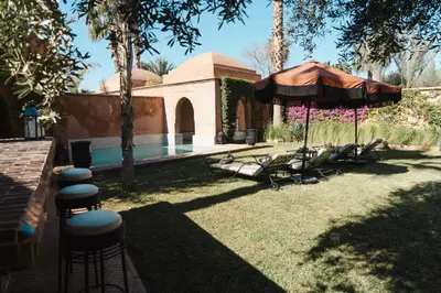 a backyard with a swimming pool and an umbrella at Villa Riad Marrakech in Najem