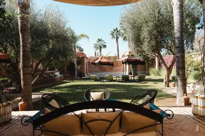 a patio with a table and chairs and trees at Villa Riad Marrakech in Najem