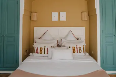 a bedroom with a white bed with white pillows at Villa Riad Marrakech in Najem