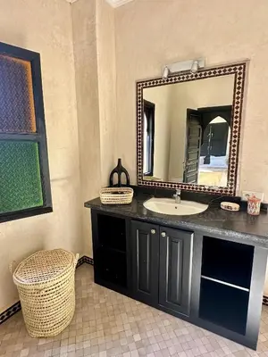 a bathroom with a sink and a mirror at Villa Atika - Maison d'Hôtes & SPA in El Bougaria