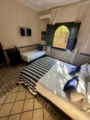a large bedroom with two beds and a window at Villa Atika - Maison d'Hôtes & SPA in El Bougaria