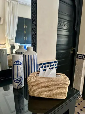 a table with two vases and a basket on it at Villa Atika - Maison d'Hôtes & SPA in El Bougaria
