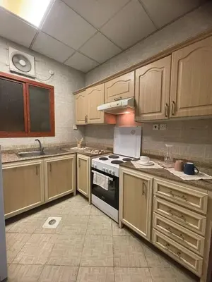 a kitchen with wooden cabinets and a stove top oven at altijan