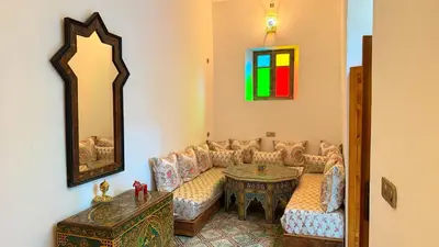 a living room with a couch and a table and a mirror at Dar Fayrouz in Fès