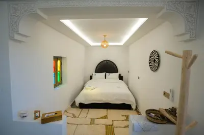 a bedroom with a bed in a white room at Dar Fayrouz in Fès