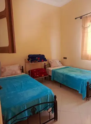 a bedroom with two beds and a suitcase in it at taddart in Merzouga