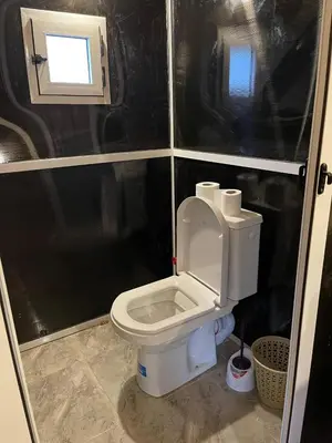 a small bathroom with a toilet with the lid up at Luxury camp in Merzouga
