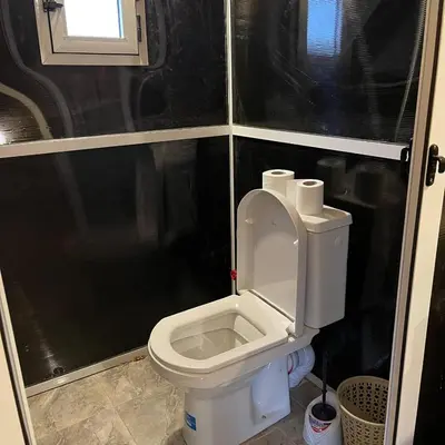 a small bathroom with a toilet with the lid up at Luxury camp in Merzouga