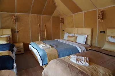 a room with two beds in a tent at Ousaadi luxury desert camp in Merzouga