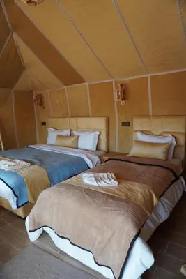 a room with two beds in a tent at Ousaadi luxury desert camp in Merzouga