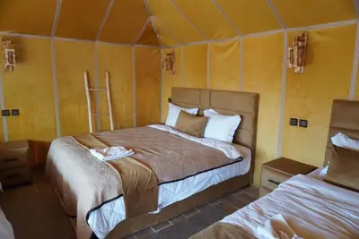 a bedroom with two beds in a tent at Ousaadi luxury desert camp in Merzouga