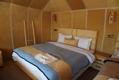 a bedroom with a large bed in a tent at Ousaadi luxury desert camp in Merzouga