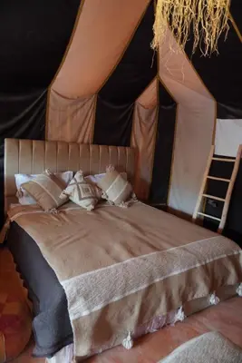 a bedroom with a bed in a tent at Ousaadi luxury desert camp in Merzouga