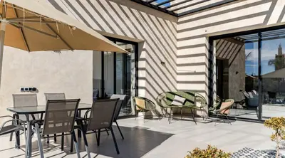 a patio with chairs and a table with an umbrella at Villa Dar Jannat Marrakech in Aït Namous