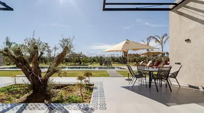 a patio with a table and chairs and a pool at Villa Dar Jannat Marrakech in Aït Namous