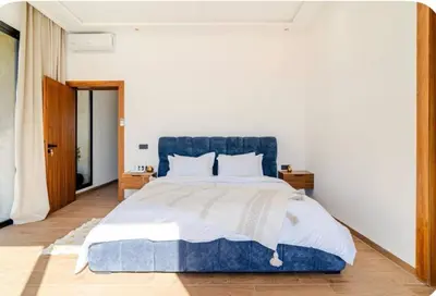 a bedroom with a blue bed and white walls at Villa Dar Jannat Marrakech in Aït Namous
