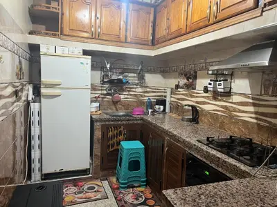 a kitchen with wooden cabinets and a white refrigerator at Charmante Maison et Comfortable à Ifrane in Ifrane