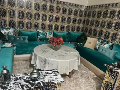 a living room with a couch and a table with flowers at Charmante Maison et Comfortable à Ifrane in Ifrane