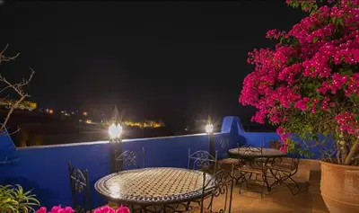 a patio with tables and chairs on a blue wall at riad dar traditional in Fès