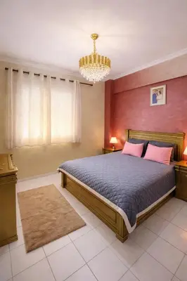 a bedroom with a bed and a chandelier at Fes Saiss Residence in Fès
