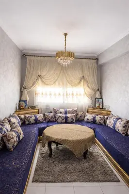 a living room with blue couches and a large window at Fes Saiss Residence in Fès