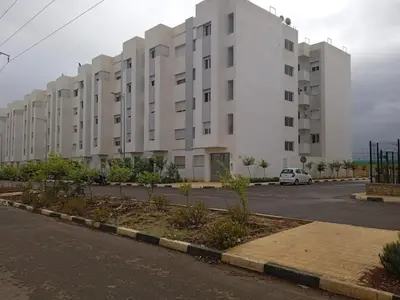 a large white apartment building with a parking lot at Fes Saiss Residence in Fès