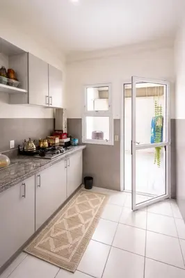 a kitchen with white cabinets and a refrigerator at Fes Saiss Residence in Fès