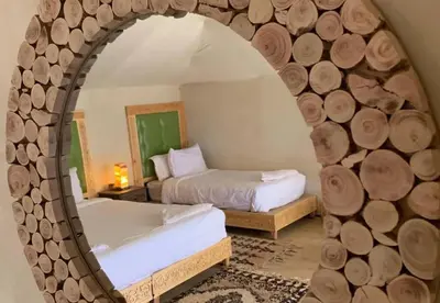 a bedroom with two beds and a mirror at Celestial Dunes Camp in Merzouga
