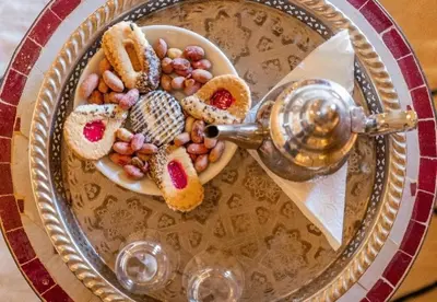 a plate of food with a bowl of beans and bread at Celestial Dunes Camp in Merzouga