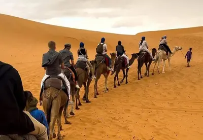 a group of people riding horses in the desert at Celestial Dunes Camp in Merzouga